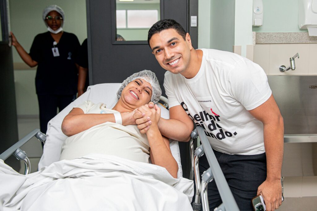 Patient in hospital bed with visiting family member, expressing joy and support.
